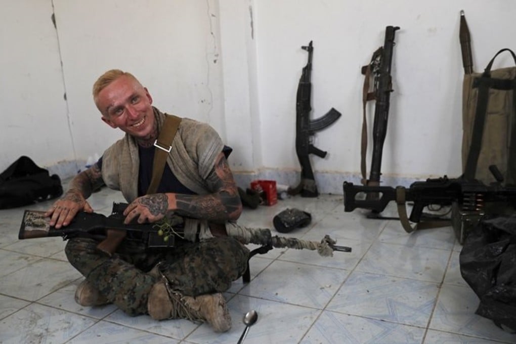 In July 17 photo, Kevin Howard, shows off his sniper rifle that he uses as he fights alongside an Assyrian militia against the Islamic State, on the western side of Raqqa, in northeast Syria. Photo: AP