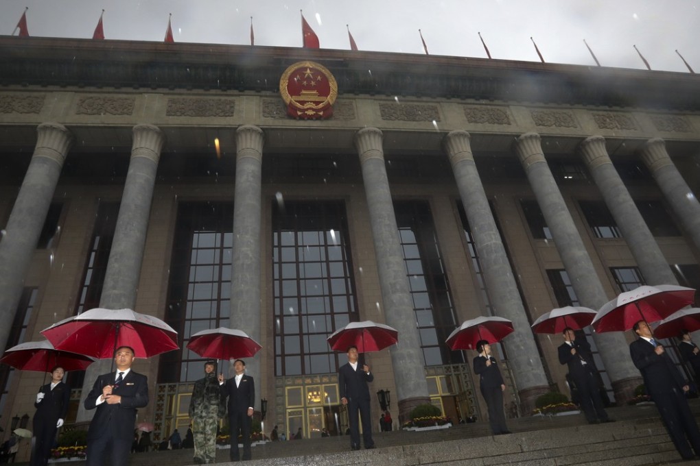 Security officers hold umbrellas in the rain outside the Great Hall of the People as they wait for delegates to arrive for the opening ceremony of the Communist Party’s national congress on Wednesday. Photo: AP