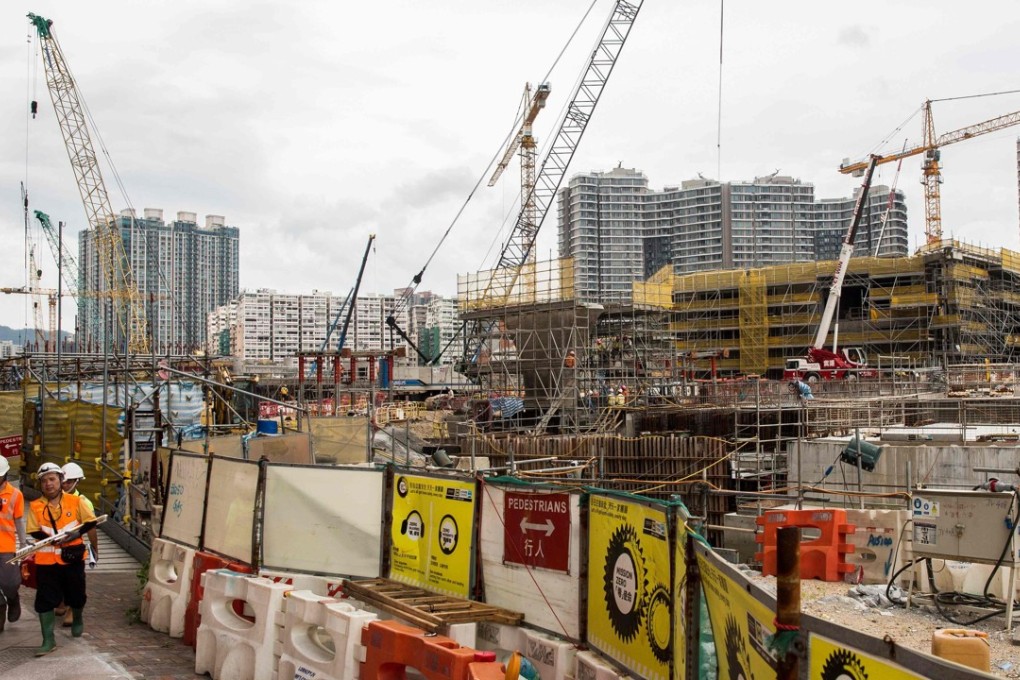 Contruction workers walk near the construction site for the West Kowloon terminus of the high-speed rail link connecting Hong Kong to Guangzhou. Photo: AFP