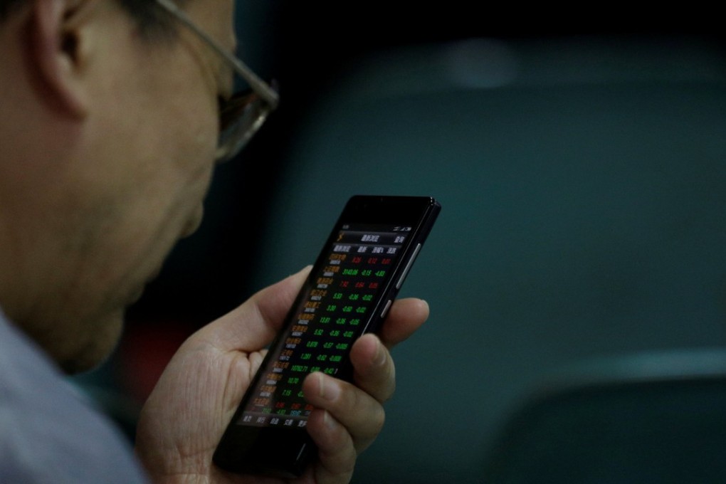 An investor checks stock information on a mobile phone. For the small investor the danger now is getting squeezed into what could be the last legs of the rally. Photo: Reuters