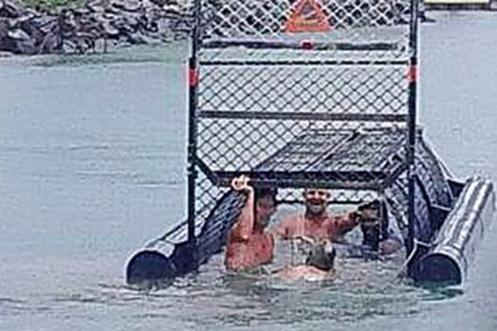 The men were photographed swimming inside the baited crocodile trap near where a woman was recently eaten. Photo: Facebook