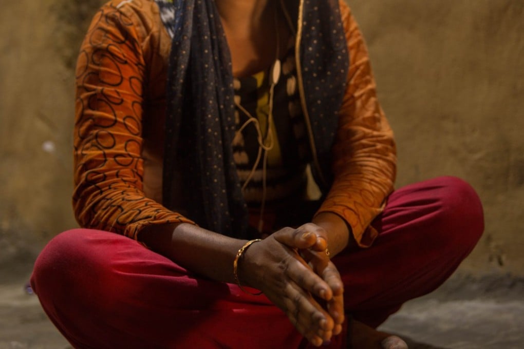 Rena, 18, sits in a mud hut with doors and windows closed as she tells her story of working as a prostitute in Kutupalong, Bangladesh. Photo: Thomson Reuters Foundation