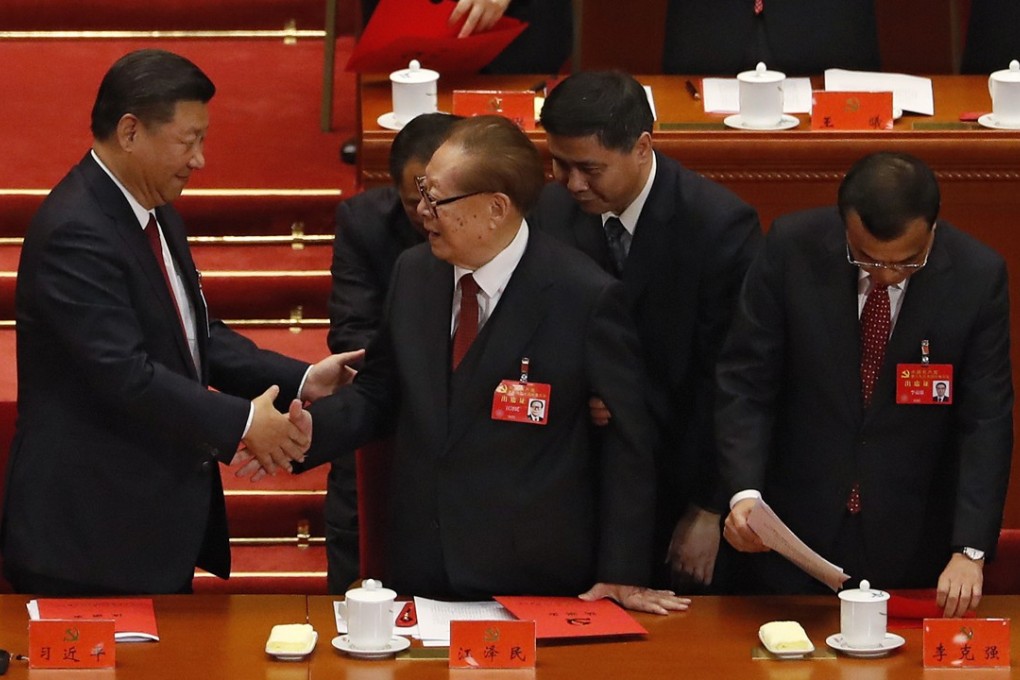 Former President Jiang Zemin (centre) is flanked by attendants as he shakes hands with Xi Jinping on the closing day of the party congress. The 91-year-old appeared tired after a long week in Beijing. Photo: AP