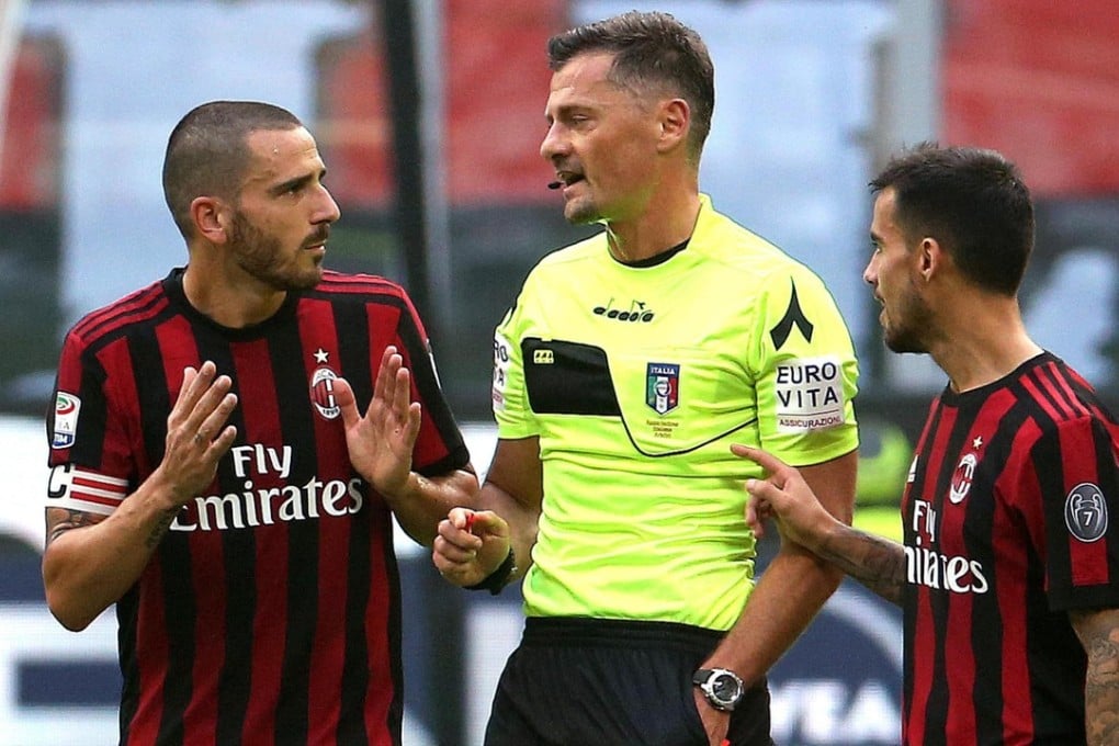 AC Milan defender Leonardo Bonucci, left, speaks with referee Piero Giacomelli, centre, after receiving a red card during a Serie A soccer match between AC Milan and Genoa, at the Giuseppe Meazza stadium in Milan, Italy. He was given a two-game ban. Photo: AP