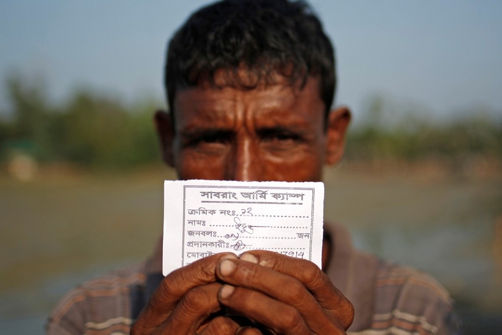 Mohammed Yousuf, 45, a Rohingya refugee, shows his permit provided by the Bangladeshi army to continue his way after crossing the Bangladesh-Myanmar border. Myanmar and Bangladesh have agreed to cooperate on repatriating Rohingya that fled violence. Photo: Reuters