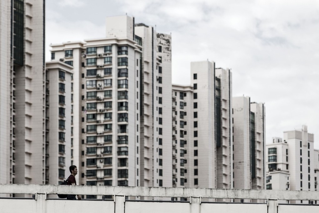 A pedestrian walks along a bridge past residential buildings in Shanghai, China, on Friday, September 29, 2017. China's earliest economic indicators hinted that growth continued to moderate in September as official drives to curb debt risk and clear the skies weighed on activity. Photo: Bloomberg