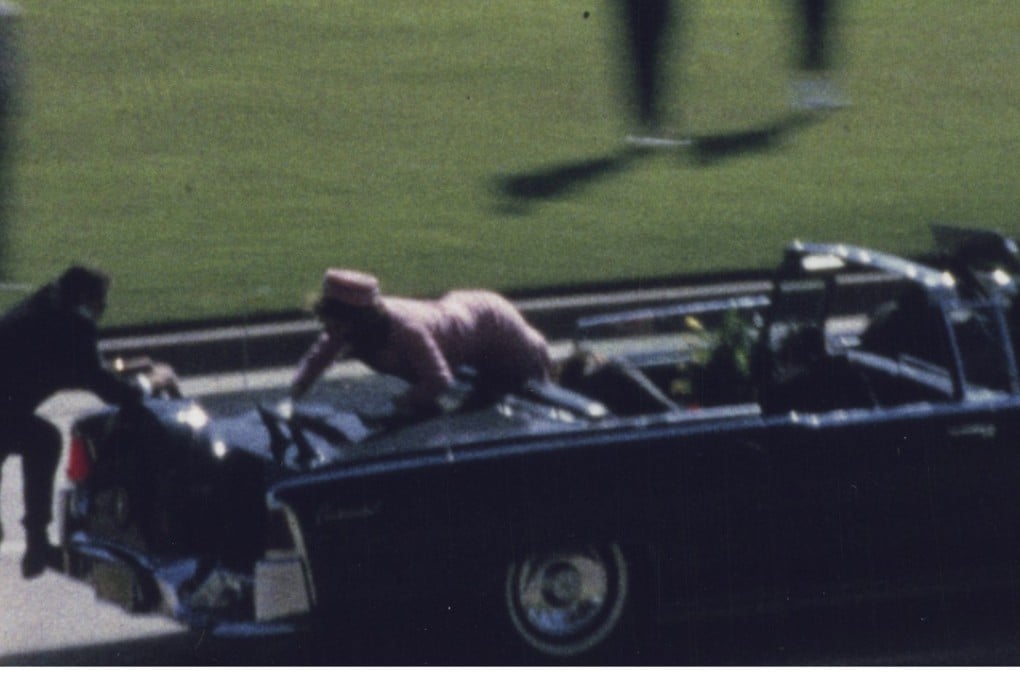 In Frame 375 of the Zapruder film, first lady Jacqueline Kennedy crawls toward the back of the presidential limousine as Secret Service agent Clint Hill scrambles to help her. Photo: Zapruder Film ©, The Sixth Floor Museum at Dealey Plaza