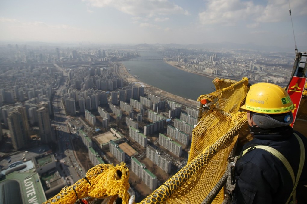 A construction worker looks out from 99th floor of Lotte World Tower in Seoul. Photo: REUTERS/Kim Hong-Ji