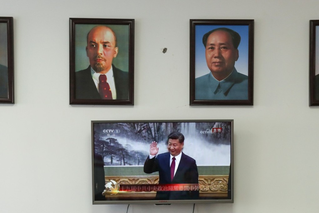 Framed portraits of German philosopher Karl Marx, Soviet state founder Vladimir Lenin and China's late leaders Mao Zedong and Deng Xiaoping (L-R) hang above a screen showing a news broadcast of China's President Xi Jinping attending a meeting in Beijing, as party members gather to watch the broadcast in Wenzhou, Zhejiang province, China October 25, 2017. Photo: Reuters