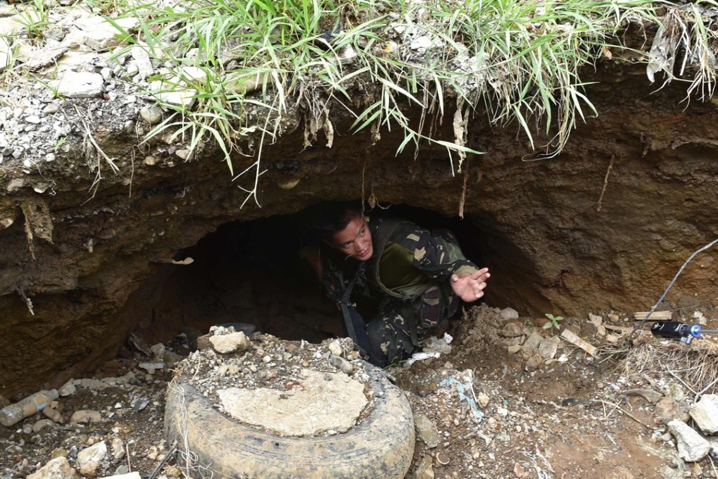 A soldier inspects a tunnel connected to the city's underground drainage system, used by militants as cover during the height of battle with government troops. Photo: AFP