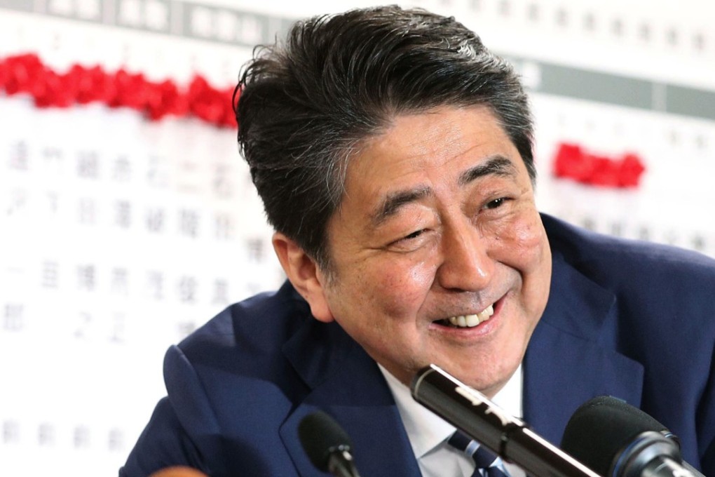 Japanese Prime Minister Shinzo Abe smiles at the Liberal Democratic Party's headquarters in Tokyo on Sunday as news of LDP candidates’ victories come in. Photo: Kyodo