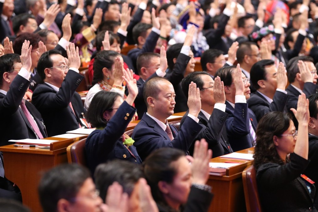 Delegates raise their hands during the closing session of the 19th National Congress of the Communist Party of China on Tuesday. Photo: Xinhua