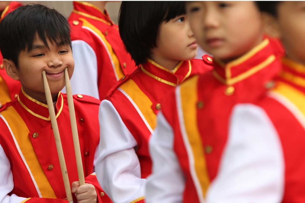 One young musician amuses himself while waiting to perform at the Hong Kong Marching Band Parade, in Tsim Sha Tsui in December 2012. Photo: David Wong