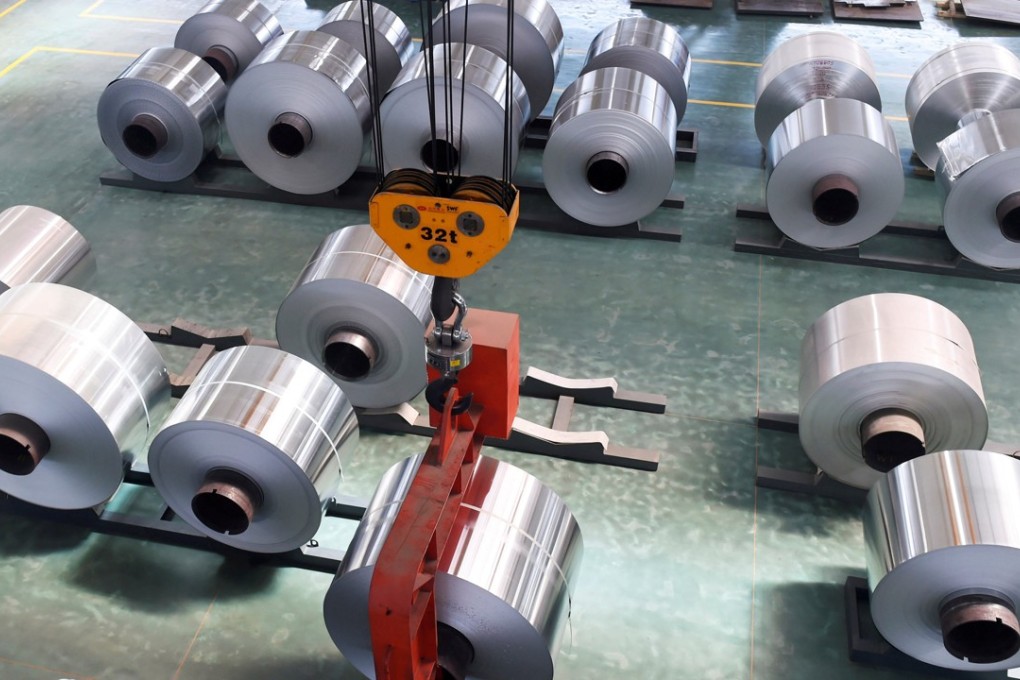 An employee looks at an aluminium foil roll being lifted at a plant in Shandong province, China. The US slapped anti-dumping duties on Chinese aluminium foil. Photo: Reuters