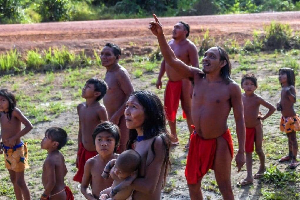 Waiapi people look at a plane flying over the Waiapi indigenous reserve in Amapa state in Brazil. Photo: AFP