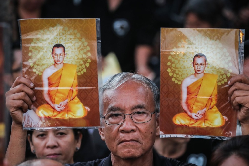 A Thai mourner holds a picture of the late Thai King Bhumibol Adulyadej as he waits for the royal cremation ceremony outside the Royal Palace in Bangkok. Photo; EPA