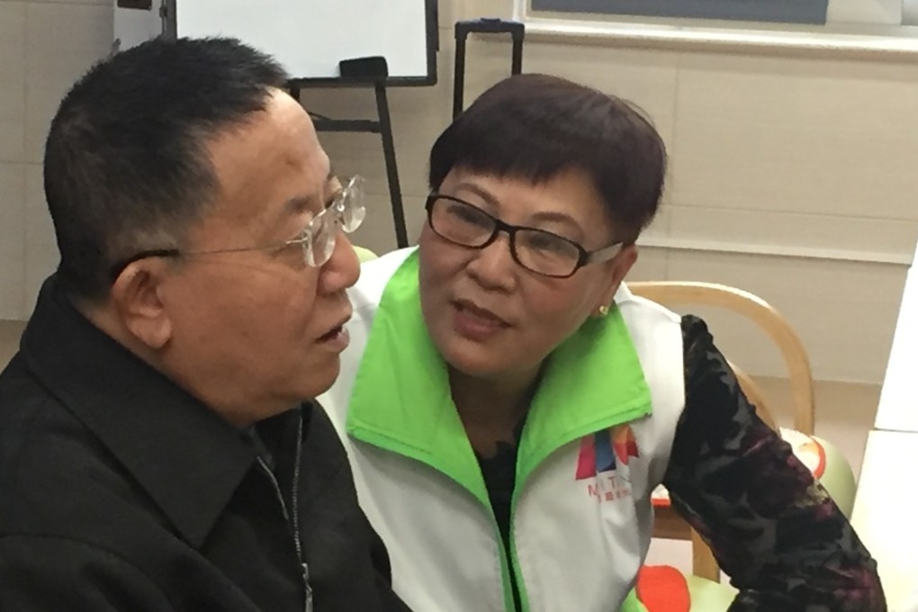 Nursing worker Xu Maohua chats with dementia patient Zou Zhengming. Photo: Alice Yan