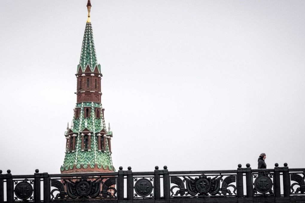 A woman crossing a bridge near the Kremlin tower in central Moscow. Photo: AFP