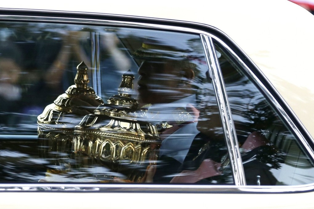 Thai King Maha Vajiralongkorn Bodindradebayavarangkun (left) and Princess Maha Chakri Sirindhorn with the royal relics and ashes of the late Thai King Bhumibol Adulyadej in a car during the procession for the transferring of the relics and ashes to temples on October 29, 2017. Photo: EPA