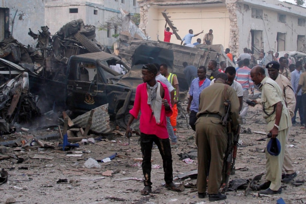 Somali security officers assess the damage at the scene of a suicide car bomb explosion. Photo: Reuters