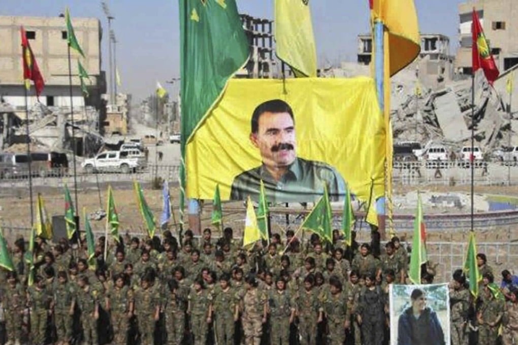 This frame grab from a video shows members of a Kurdish female militia, the Women’s Protection Units, under a portrait of their jailed leader, Abdullah Ocalan, as they celebrate victory against the Islamic State group, in Raqqa, Syria. Photo: AP