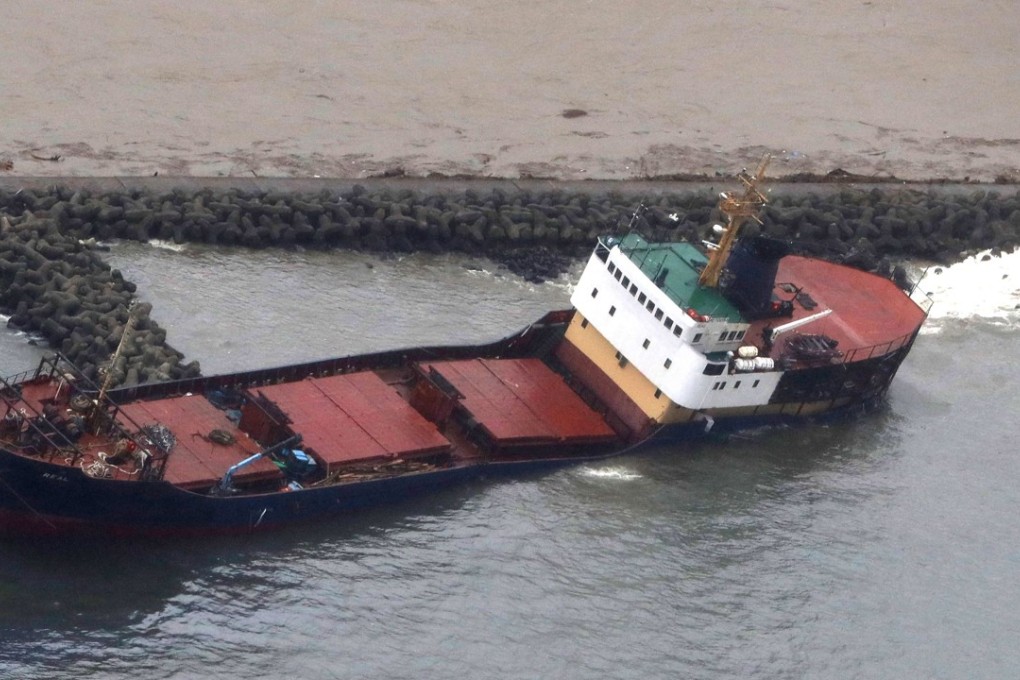 A listing cargo ship at a port in the Sea of Japan that ran onto a breakwater due to strong wind from powerful Typhoon Lan. Photo: Kyodo