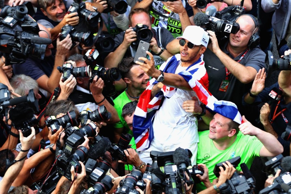 Lewis Hamilton takes a selfie as be is besieged by the world’s media after winning his fourth world title despite a ninth-place finish at the Mexican Grand Prix. Photo: AFP