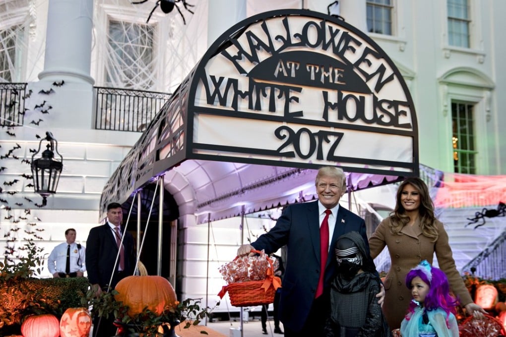US President Donald Trump and First Lady Melania Trump, right, pose for a photograph with trick-or-treaters during a Halloween event on the South Lawn of the White House on Monday. Photo: Bloomberg