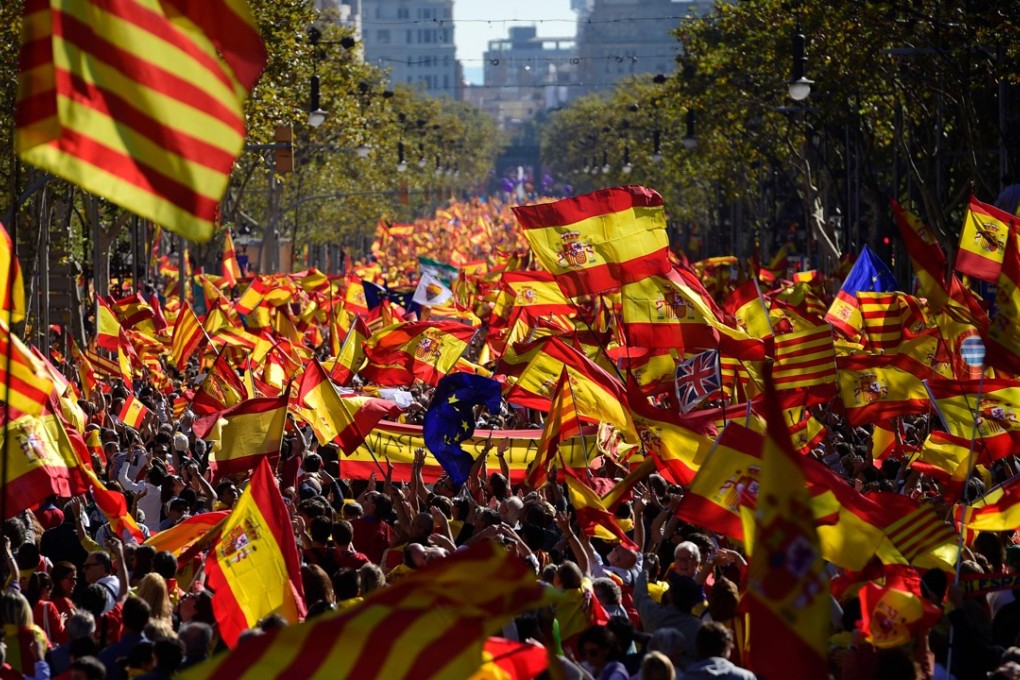 Protesters wave Spanish and Catalan Senyera flags during a pro-unity demonstration in Barcelona. Photo: AFP