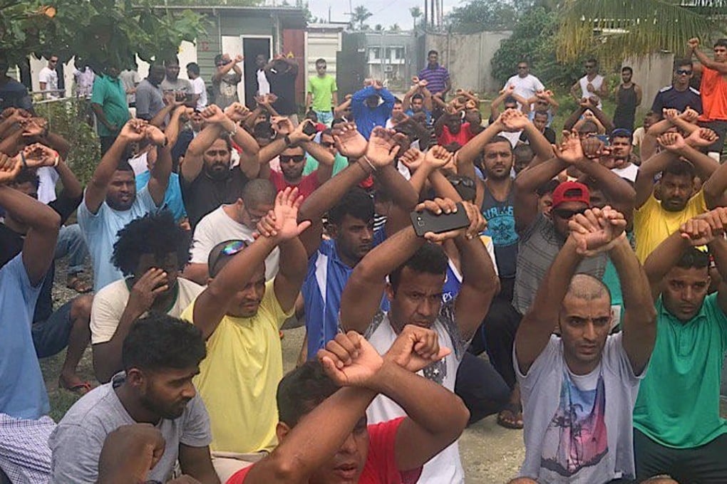 Detainees raise their arms as they protest inside the Manus Island detention centre in Papua New Guinea. Photo: Reuters
