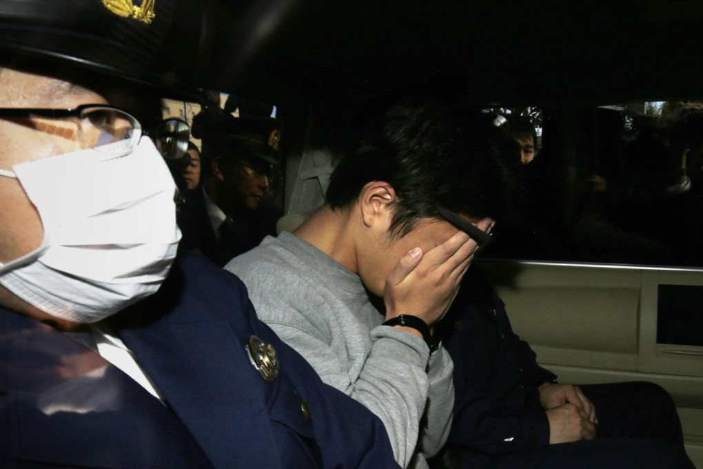 Suspect Takahiro Shiraishi covers his face with his hands as he is transported to the prosecutor's office from a police station in Tokyo. Photo: AFP