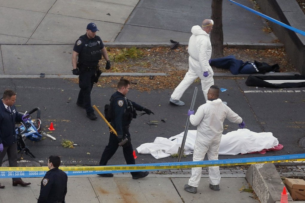 Authorities investigate the scene near a covered body on a bike path after a motorist drove onto the path near the World Trade Centre memorial. Photo: AP