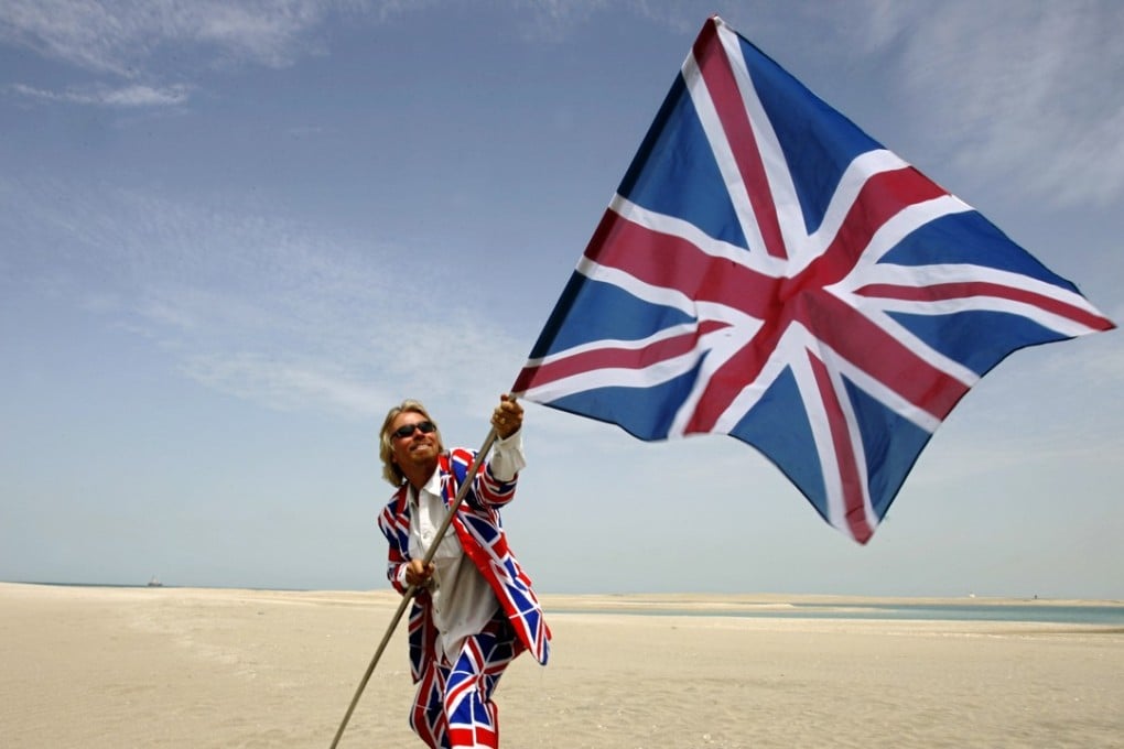 Richard Branson plants a Union flag in the British section of a map-of-the-world-shaped property development in Dubai. Picture: AFP