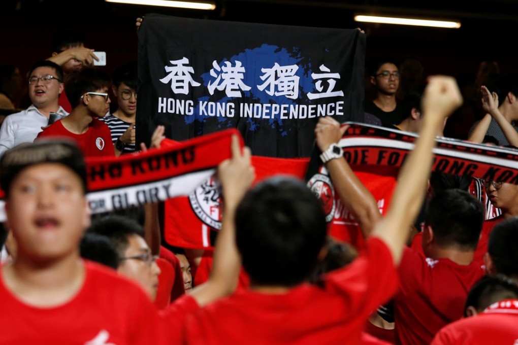 A banner calling for Hong Kong independence is held up by Hong Kong football fans as the national anthem is played before a match between Hong Kong and Malaysia on October 10. Some fans also booed and turned their backs to the pitch. Such behaviour may be offensive and disrespectful. But it is not a crime. Photo: Reuters