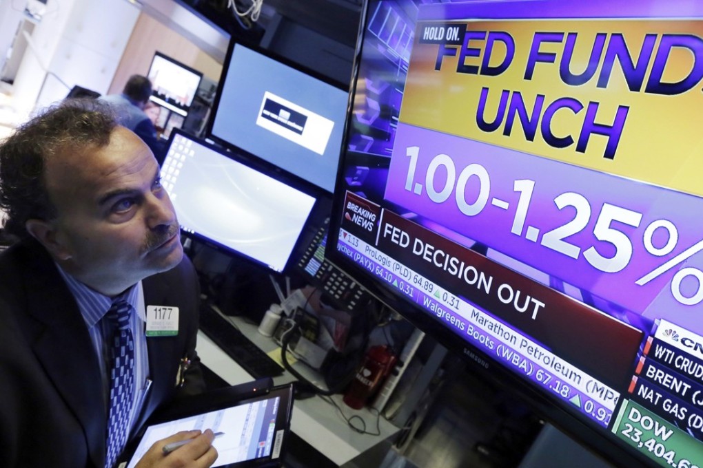 Trader Gerard Farco watches a television on the floor of the New York Stock Exchange showing the rate decision of the Federal Reserve on Wednesday, November 1, 2017. Photo: AP