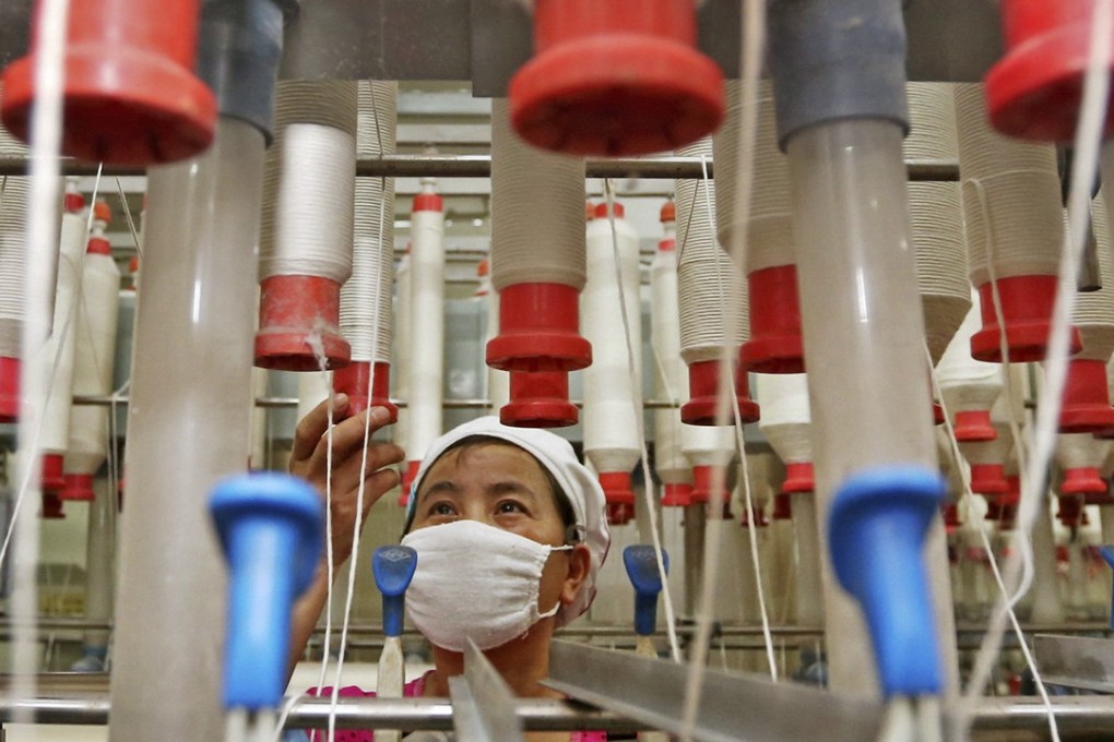 A worker checks cotton thread barrels in a textile factory in Huaibei, Anhui province, one of the major sources of migrant workers to the more prosperous and developing parts of China, such as the Pearl River Delta. But rising wages, increased reliance on automation and changing technology may put their jobs on the line. Photo: AP