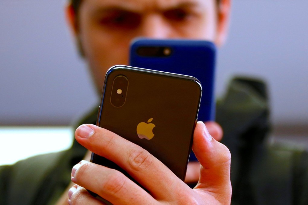 A customer uses his iPhone 7 to take a photograph of the iPhone X during the global launch of the new Apple product in Sydney, Australia, on November 3, 2017. Photo: Reuters
