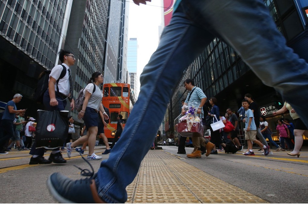 Pedestrians walks on street in Central. Will they stop if they hear the national anthem? Photo: K. Y. Cheng