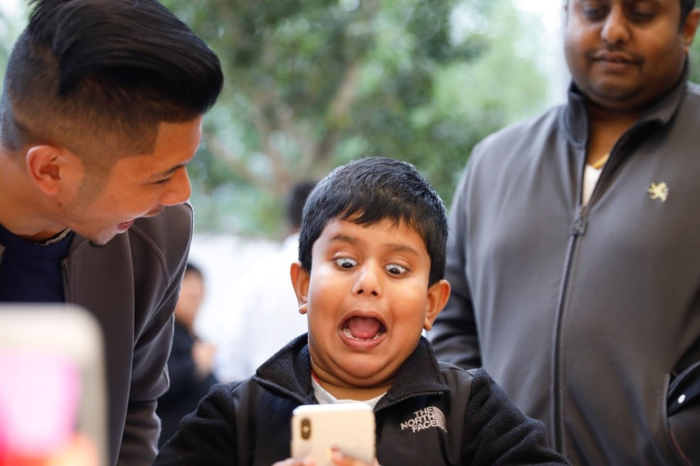 A boy makes a happy face while testing out the Animoji feature on an iPhone X at the Apple Store on November 3, 2017, in San Francisco, California. The company is tipped to approach US$1 trillion in value. Photo: Agence France-Presse