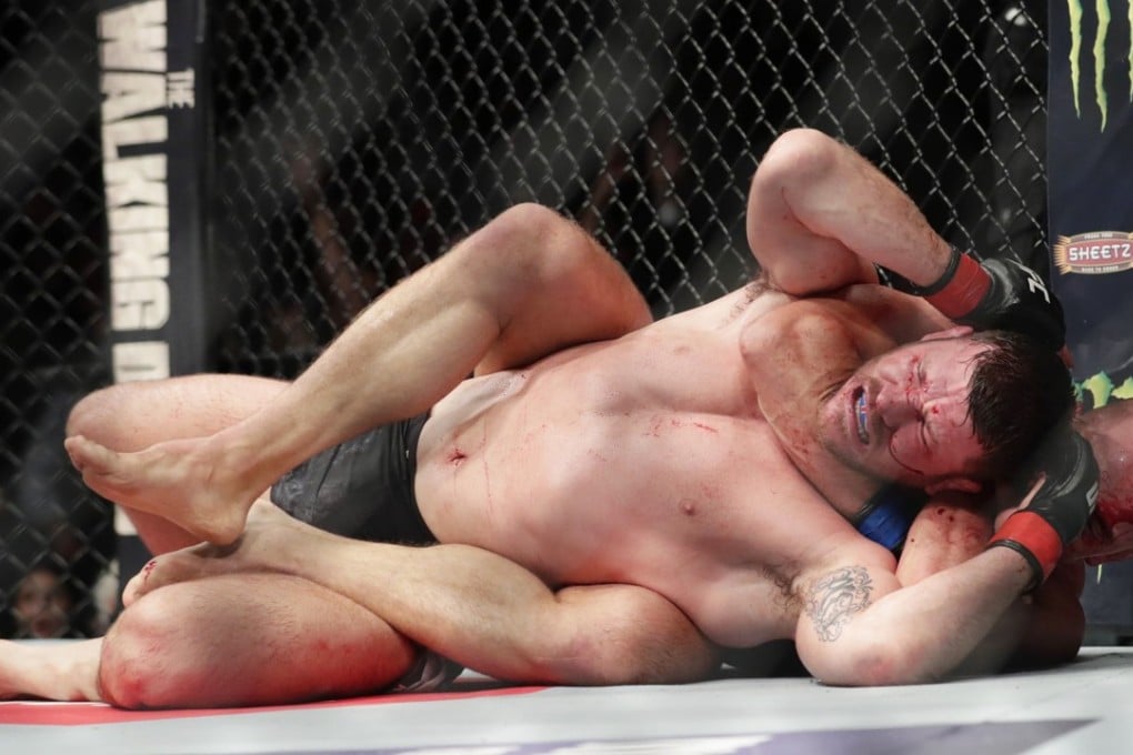 Georges St. Pierre chokes Michael Bisping during their middleweight title fight at UFC 217. Photo: AP