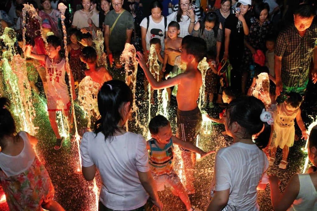 This file photo taken on July 23, 2017 shows children and adults playing in a fountain to cool off during a heatwave in Yangzhou, China's eastern Jiangsu province. The year 2017 is on track to be the hottest year on record. Photo: Agence France-Presse