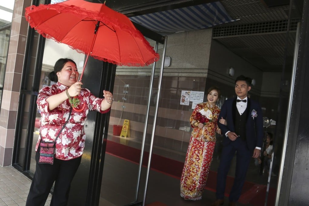 Bride Crystal Wong Po-ching and groom Ronnie Suen Che-nam are accompanied by wedding chaperone Choi Lai-Kwan in a wedding ceremony in Tuen Mun. Photo: Jonathan Wong