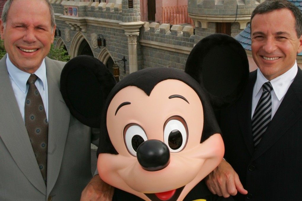 Michael Eisner, left, Disney Chairman and CEO of the Walt Disney Company and Robert Iger, right, president of the Walt Disney Company pose with Mickey Mouse. Photo: AP/Kin Cheung