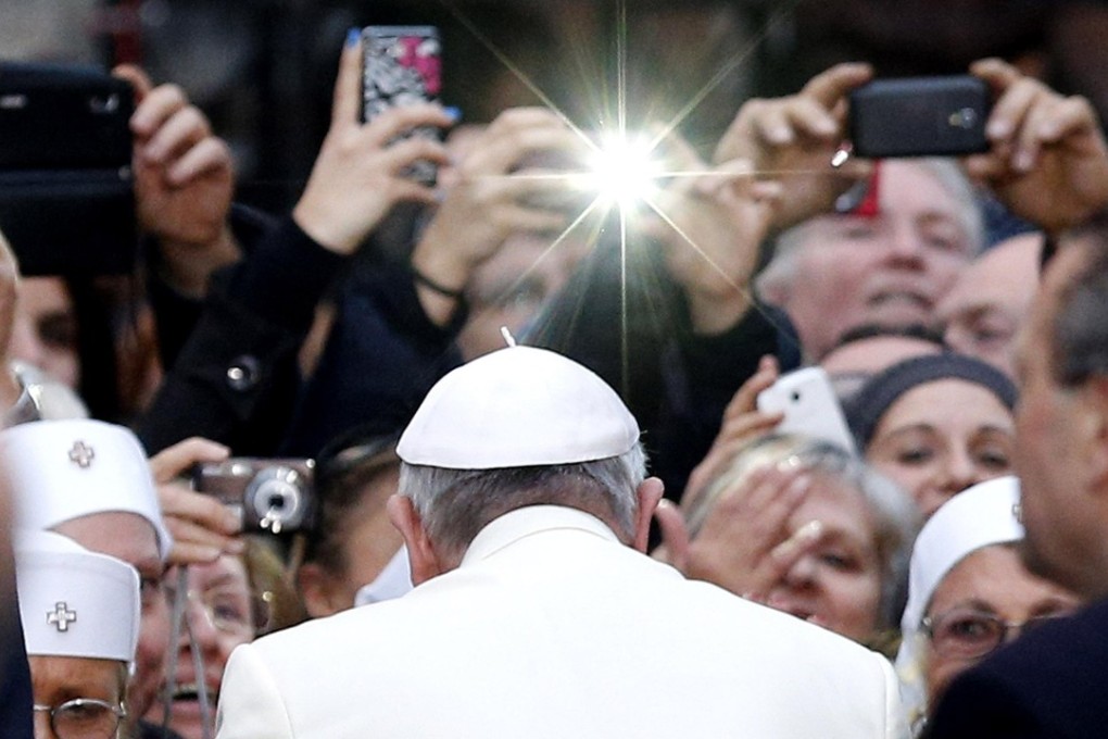 A group of nuns and others use their mobile phones to photos of Pope Francis. Photo: EPA