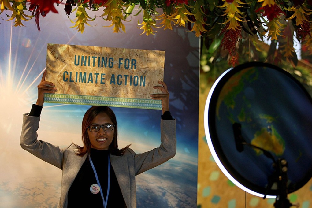 A woman holds up a placard calling for climate action during the COP23 United Nations Climate Change Conference on November 8, 2017 in Bonn, Germany. Photo: Agence France-Presse