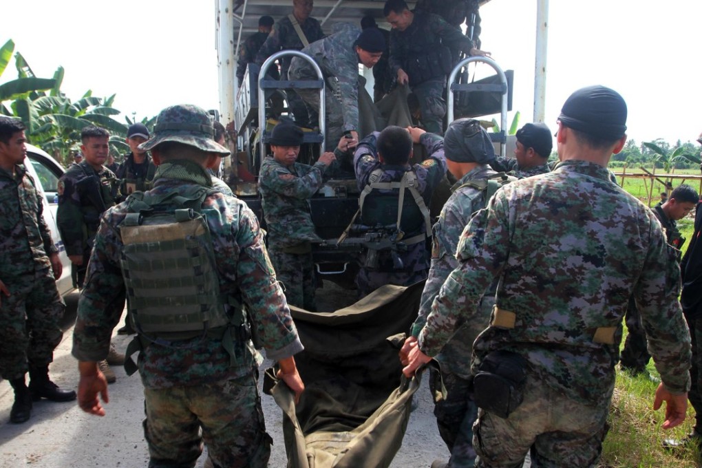 Philippine police commandos load body bags containing their comrades killed in a clash with Muslim rebels in Mamasapano, Maguindano in January, 2015. Photo: AFP
