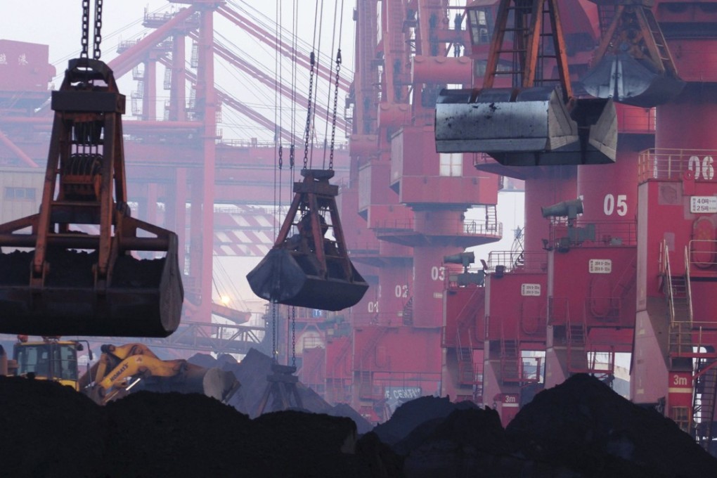 Heavy machines move imported iron ore at the dock in Rizhao in eastern China's Shandong province. China’s imports of iron ore fell sharply as it tried to fight off pollution in the country. Photo: Chinatopix via AP