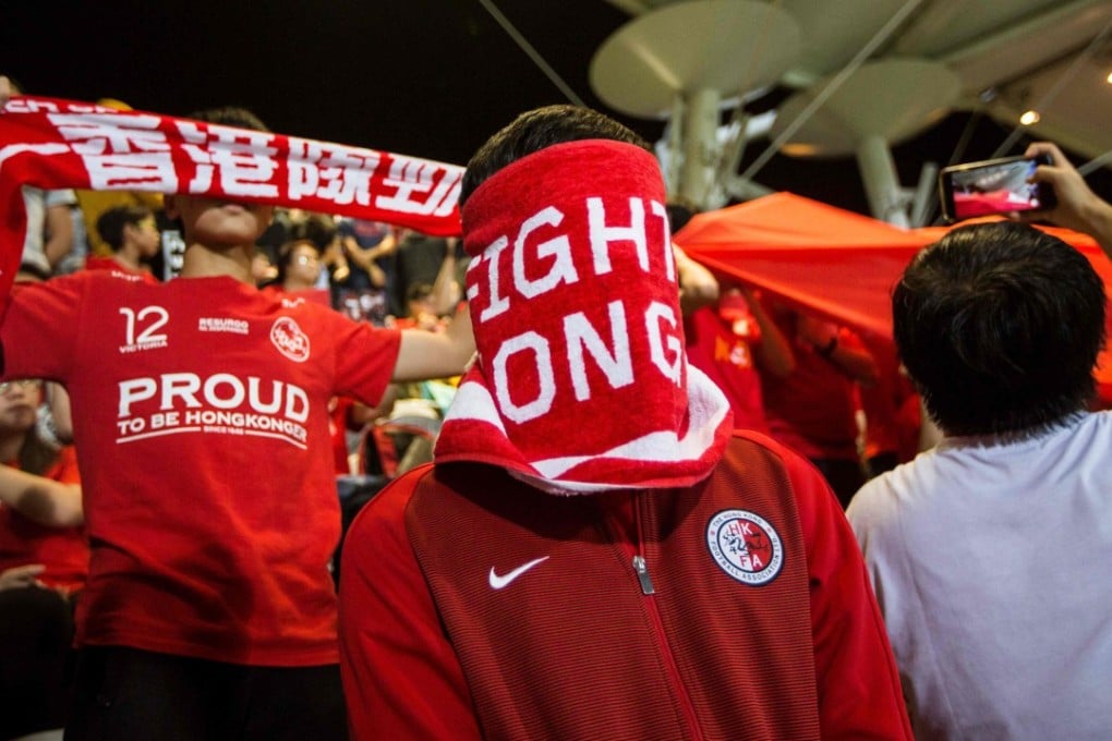 A Hong Kong fan covers his face during the Chinese national anthem before an international friendly soccer match between Hong Kong and Bahrain. Photo: AFP