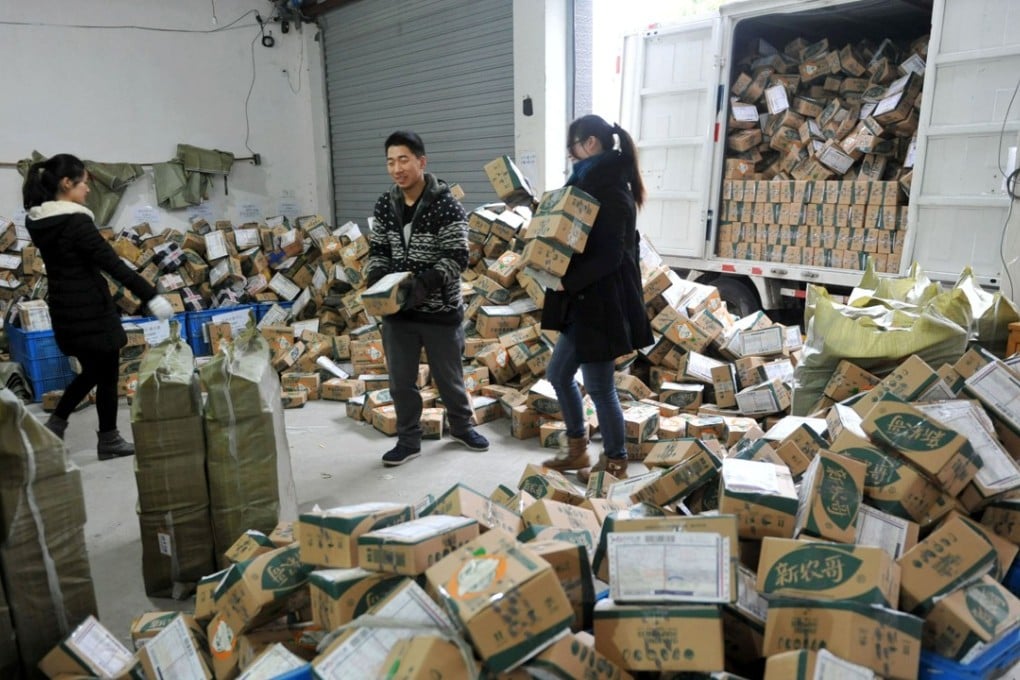 Chinese workers sort through boxes of goods at a delivery company in Lin'an, Zhejiang province on November 11, 2016. Chinese shoppers spent more than US$1 billion in the first five minutes of Singles’ Day on November 11, according to e-commerce giant Alibaba. Photo: AFP