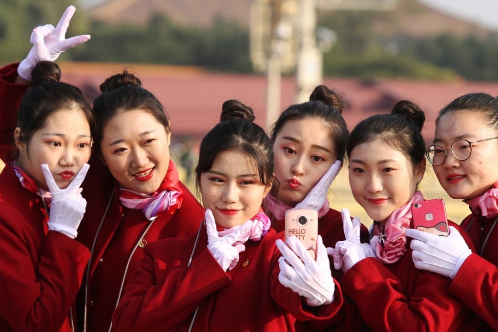 Hotel attendants for delegates pose in Tiananmen Square as the 19th party congress closed on October 24. Photo: Simon Song